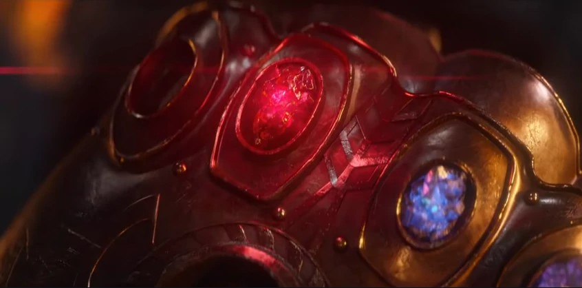 Imagem da pedra vermelha das Jóias do Infinito do universo Marvel, na manopla de Thanos.