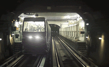 Túnel de trem subterrâneo, visto da frente de um trem que segue caminho adentro.